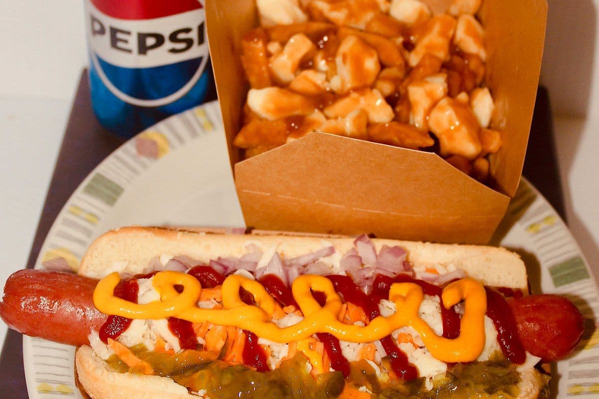 Hotdog, poutine, and a can of pop