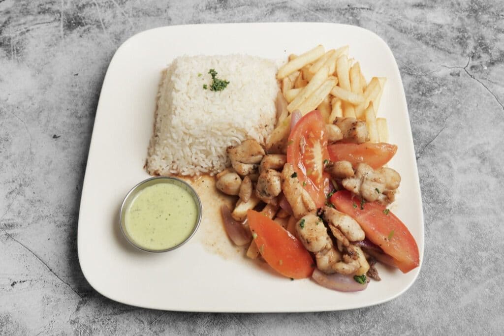 Sauté de poulet aux oignons, tomates et frites / Lomo de pollo
