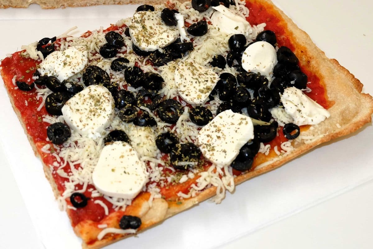 Pizza base sauce tomate, olives noires, fromages bocconcini et mozzarella