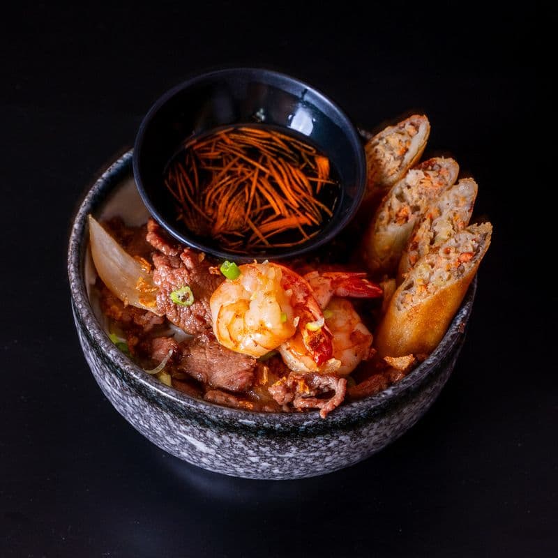 Bol de vermicelle avec bœuf, crevettes et rouleaux impériaux