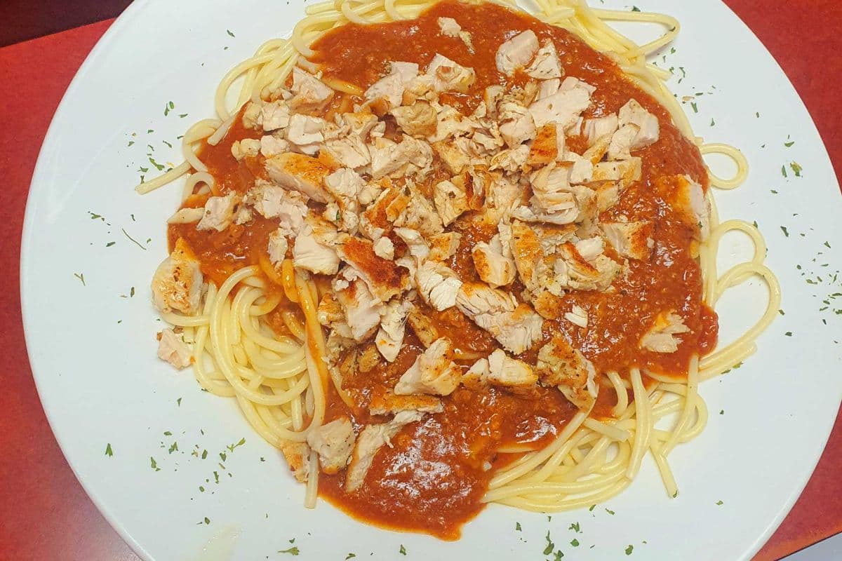 Spaghetti With Homemade Meat Sauce Topped With Grilled Chicken Breast