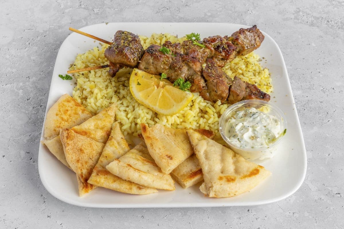 Two Pork Skewers with Rice, Tzatziki, and Pita Bread