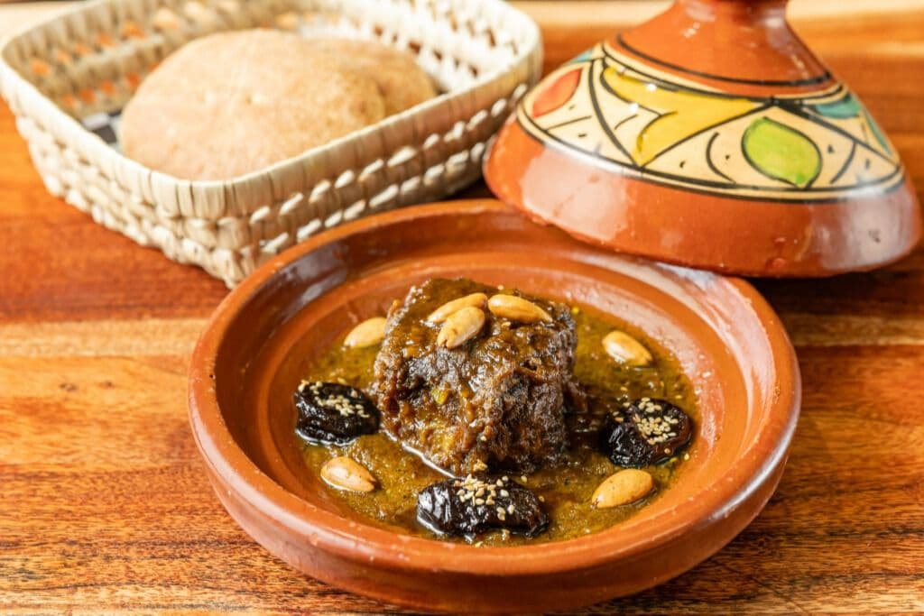 Tajine de veau aux pruneaux et amandes servi avec du pain maison